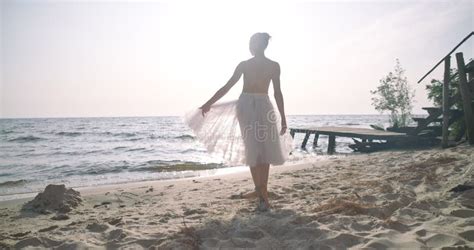 Back View Slim Woman In Tutu Dancing In Sunbeam In Slow Motion On Sea