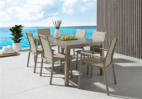 An Outdoor Dining Table And Chairs On A Patio Overlooking The Ocean