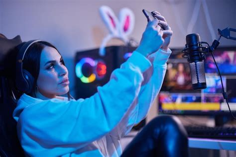 premium photo happy woman putting on headphones and playing computer game female gamer in