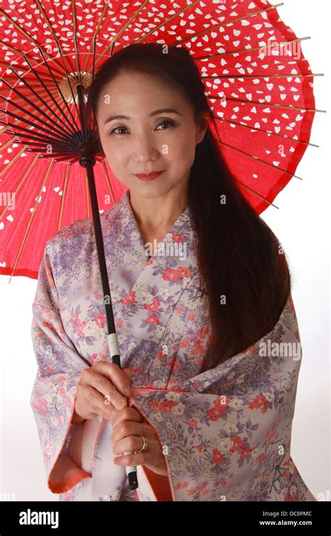Japanese Lady Wearing A Pink And Lilac Patterned Kimono And Holding A