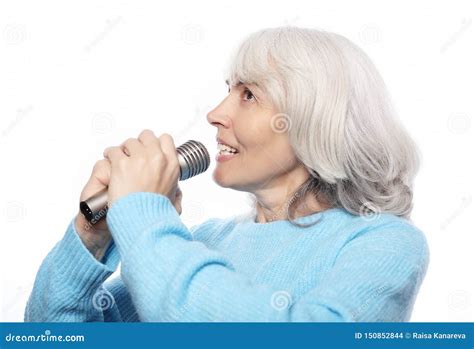 Happy Old Senior Woman Singing With Microphone Having Fun Expressing Musical Talent Over White