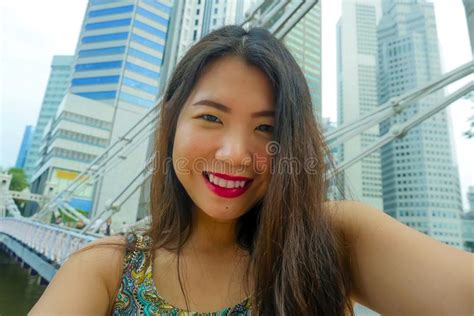 Lifestyle Portrait Of Young Beautiful And Happy Asian Chinese Tourist Woman Taking Selfie Photo