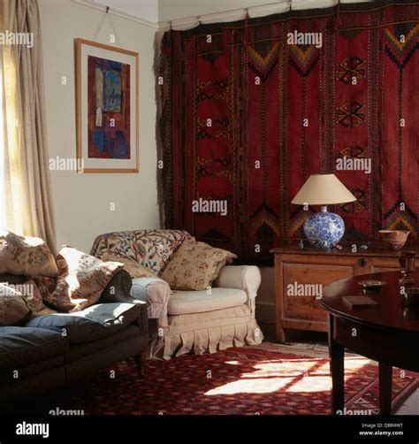 Old Red Persian Carpet Hanging On Wall In Townhouse Living Room With