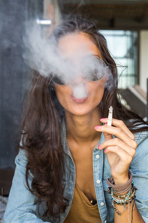 Beautiful Tanned Girl Blowing Cigarette Smoke Into The Camera By Stocksy Contributor Jovo