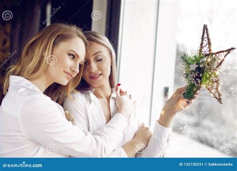 Young Blonde Lesbian Couple Holding Christmas Star Decoration In Stock