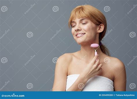 A Happy Woman With Perfect Skin Stands On A Gray Background And