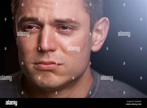Close Up Portrait Of Crying Young White Man Looking Away Stock Photo