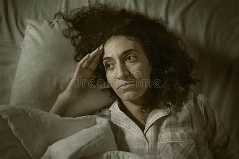 Dark And Edgy Portrait Of Depressed And Sleepless Latin Woman Lying