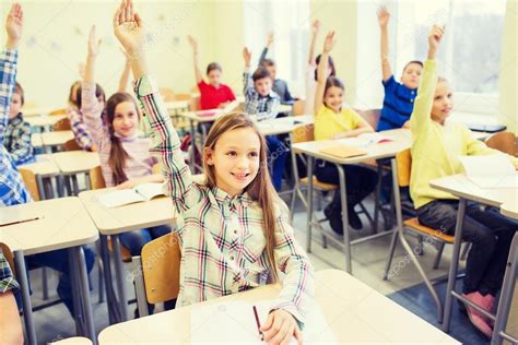 Group Of School Kids Raising Hands In Classroom — Stock Photo © Syda