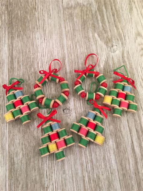 Small Christmas Ornaments Made Out Of Wooden Sticks With Red Bows And