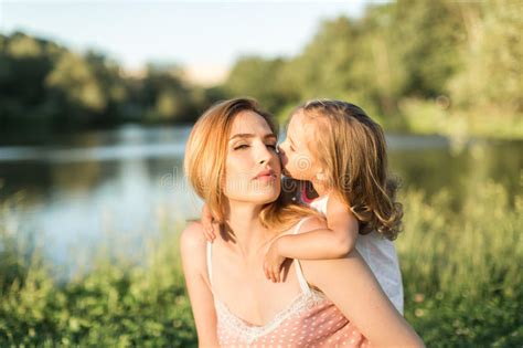 Mom And Daughter Are Sitting On A Rug By The Lake Stock Image Image