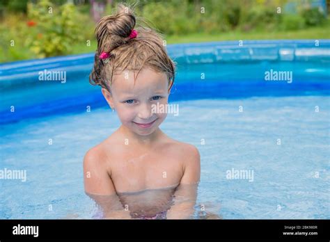 Little Girl Palying In A Swimming Pool At A Summer Garden Inflatable