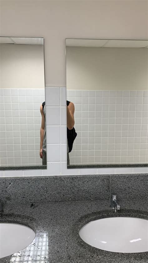 Two Sinks In A Public Restroom With Mirrors Above Them And One Person