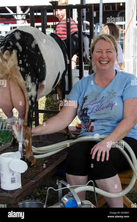 A Woman Demonstrates A Milking Machine On Her Dairy Goat At The Blue