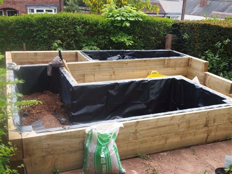 At each of the 4 inside corners of the area you marked out, drive in a heavy wooden stake. Railway sleeper beds and pond