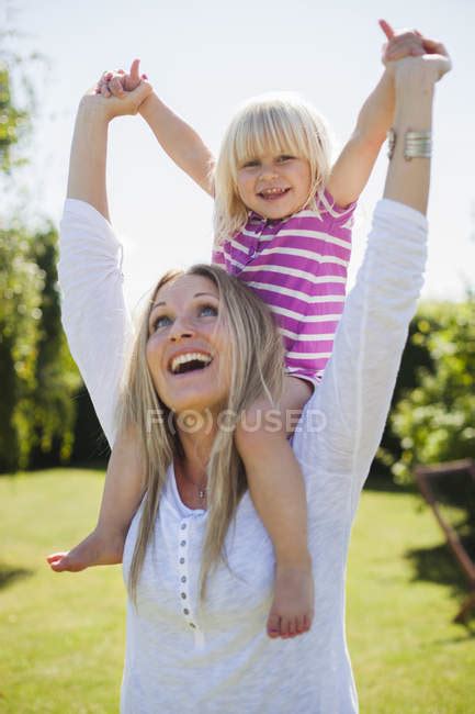 Cheerful Mother Carrying Daughter Sunlight Girl Stock Photo