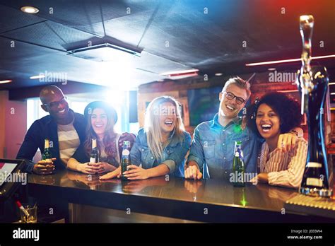 A Group Of Friends Inside The Bar Laughing While Communicating And