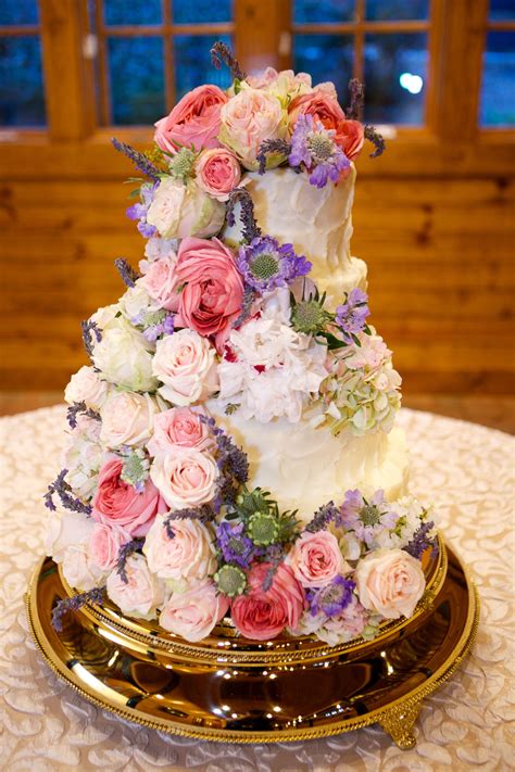 buttercream wedding cake with cascading bright roses