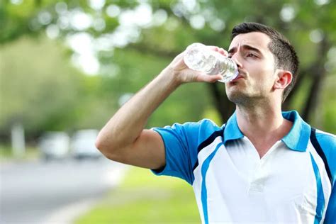 Sporty Male Runner Drinking Mineral Water At The Break After Run