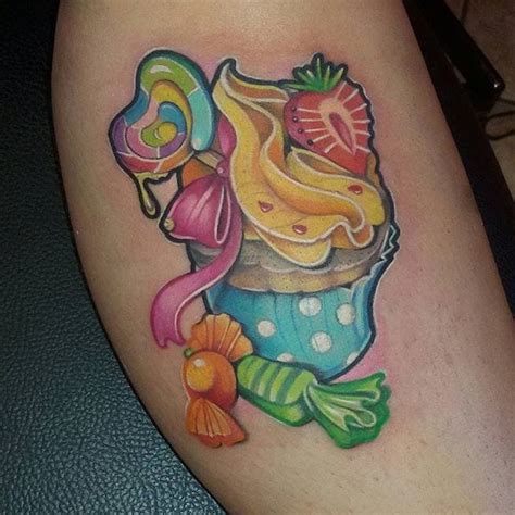 A Colorful Cupcake Tattoo On The Leg With Candy And Candies Around Its