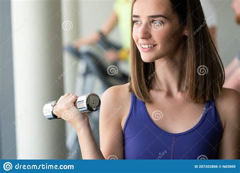 Young Beautiful Woman Doing Exercises With Dumbbell In Gym Stock Photo