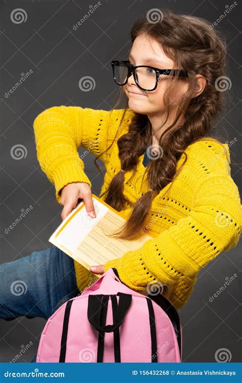 Little Schoolgirl In Eyeglasses Puting The Exercise Books In Pink
