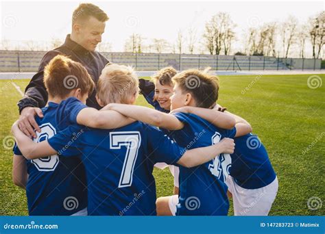 Group Of Children In Soccer Team Celebrating With Coach Stock Image