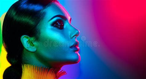 Fashion Model Woman In Colorful Bright Sparkles And Neon Lights Posing In Studio Portrait Of