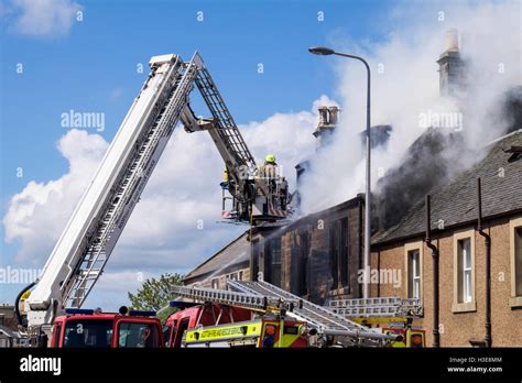 Scottish Fire And Rescue Service Firefighters Up A Ladder Tackling A