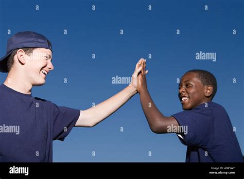 Two Teenage Boys Giving A High Five Stock Photo Royalty Free Image