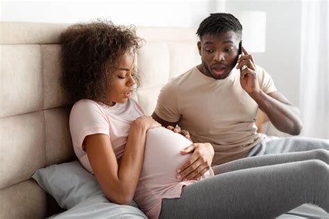 Premium Photo Worried African American Husband Calling Emergency For Pregnant Wife Indoors