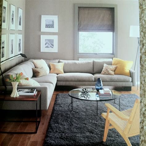 Gray floors are becoming a somewhat hot item in the modern day designs. Grey couch, yellow pillows, black & white photography ...