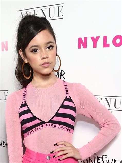 A Woman In Pink And Black Outfit Posing For The Camera With Her Hands