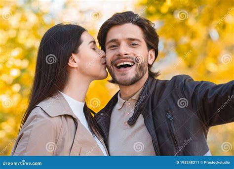 Young Woman Kissing Her Husband While Taking Selfie Stock Image Image Of Holiday Girl 198248311