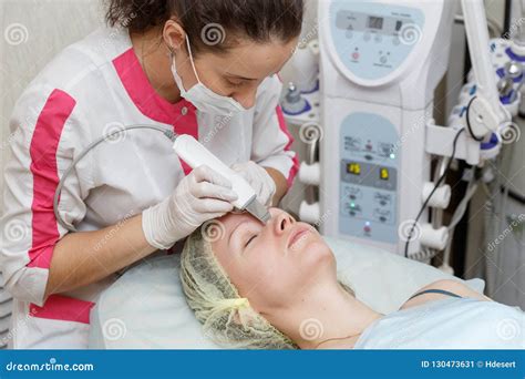 Cosmetologist Doing Procedure Cleaning Of Face With Ultrasonic Scrubber