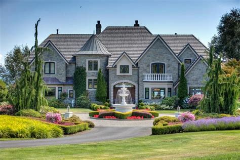 A Large House With Lots Of Trees And Flowers Around Its Front Lawn Area