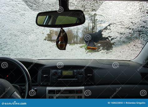 Man Scraping Ice And Snow From The Windshield Of A Car Stock Photo