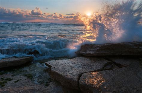 Playful Waves Splash Into A Stunning Sunset From The
