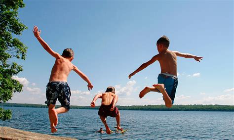 Children Jumping Into Lake On Summer Vacation Del Colaborador De