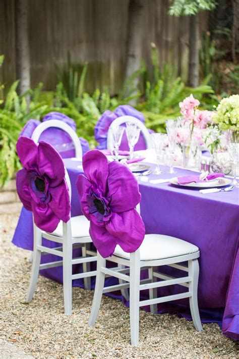 Empty wedding chairs elegantly decorated. Purple chair covers by Wildflower Linen. Table design by ...