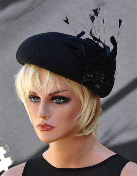 A Mannequin Head Wearing A Black Hat With Feathers