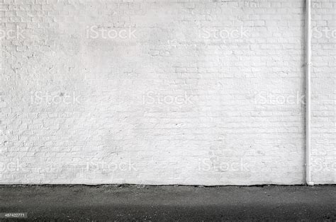 White Brick Wall And Sidewalk In An Urban Street Background Stock Photo