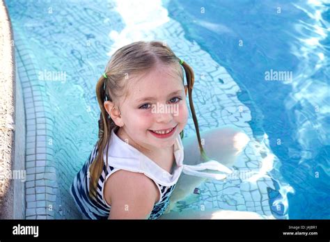 Adorable School Age Girl Sitting In Swimming Pool On Vacation Stock