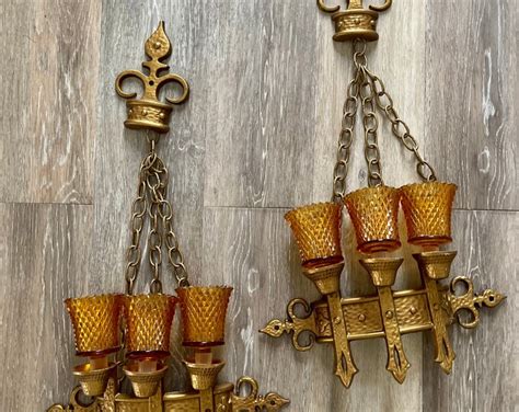 vintage pair of 1960s sexton cast iron gold wall hanging candle holders with amber glass inserts