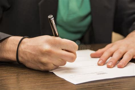Hands Of Man Signing A Sheet Of Paper Or Document Stock Image Image