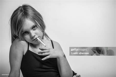 Portrait Young Girl With Cigarette In Mouth Looking At Camera High Res