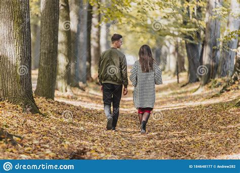 Rear View Of Young Couple Walking In Park During Autumn Stock Image