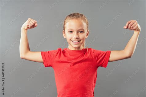 Cute Joyful Girl Flexing Her Biceps And Arm Muscles Stock Photo Adobe