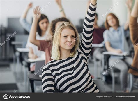 Students Rising Hands To Answer The Question Stock Photo By