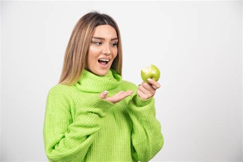 Mujer Joven En Camiseta Verde Sosteniendo Una Manzana Foto Gratis